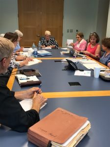 League members sitting at table during monthly board meeting
